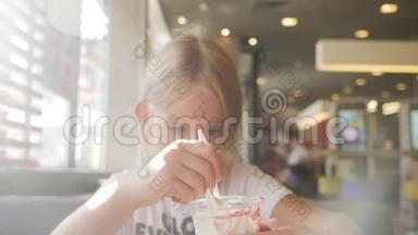 漂亮女孩在咖啡馆里吃冰淇淋。 孩子吃冰淇淋的生活方式理念..
